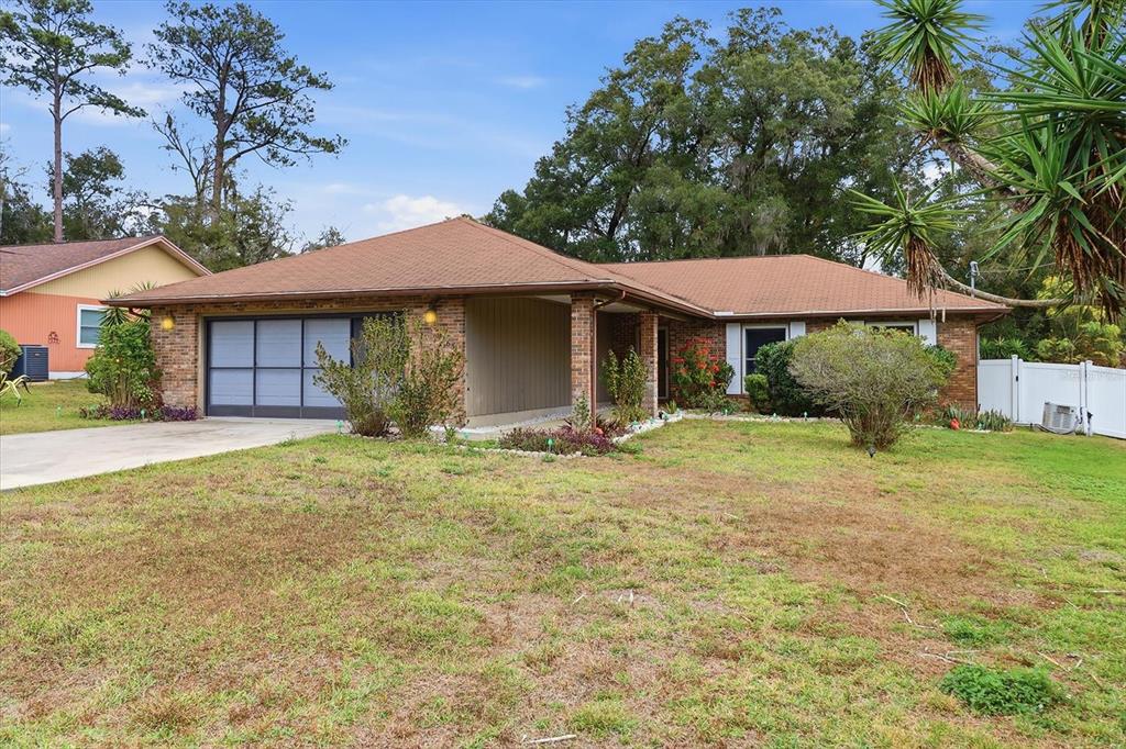 A single-story brick house with a brown roof, a garage, and a front yard — 3265 NE 30 COURT, OCALA, FL