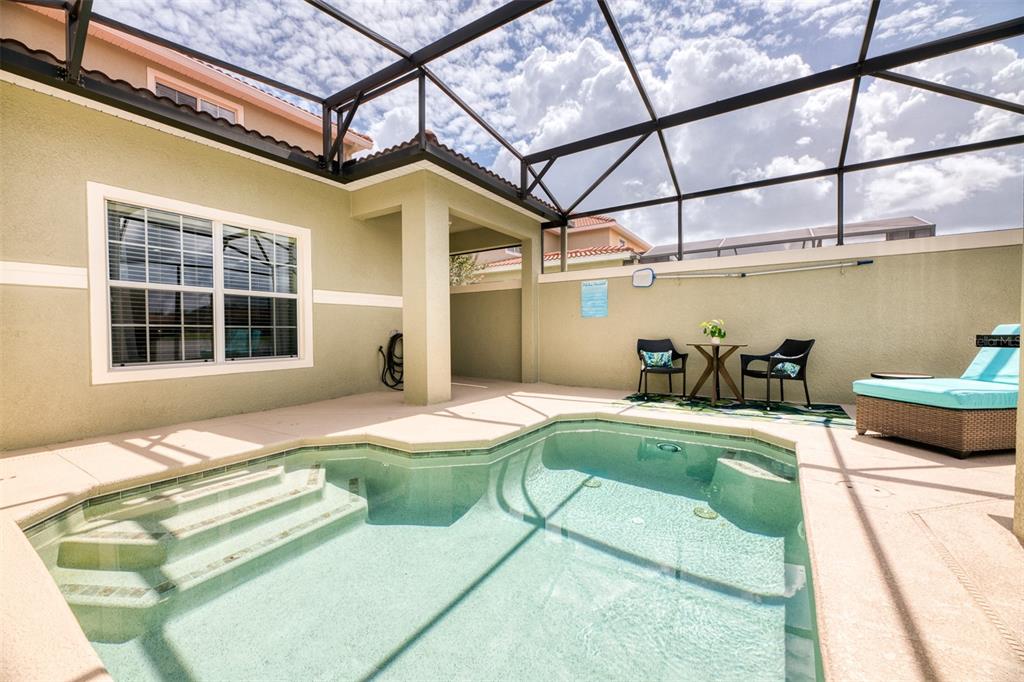 A screened-in patio features a small swimming pool, a bistro set, and a lounge chair — 8938 CUBAN PALM ROAD, KISSIMMEE, FL