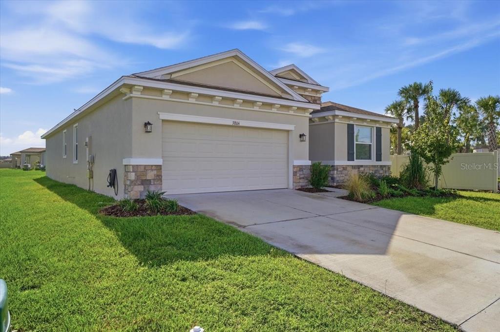 A single-story house with a two-car garage, stone accents, and a concrete driveway — 3804 N MARYLAND AVENUE, PLANT CITY, FL
