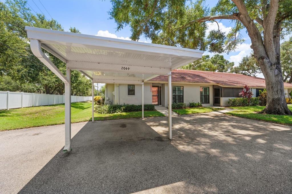 A single-story residence with a white carport and a paved driveway under large trees — 2069 LAKEVIEW DRIVE, CLEARWATER, FL