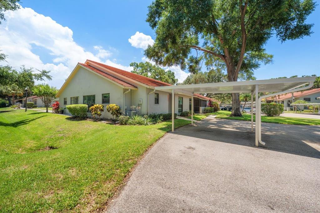 A single-story residential building with a red tile roof and an attached metal carport — 2069 LAKEVIEW DRIVE, CLEARWATER, FL