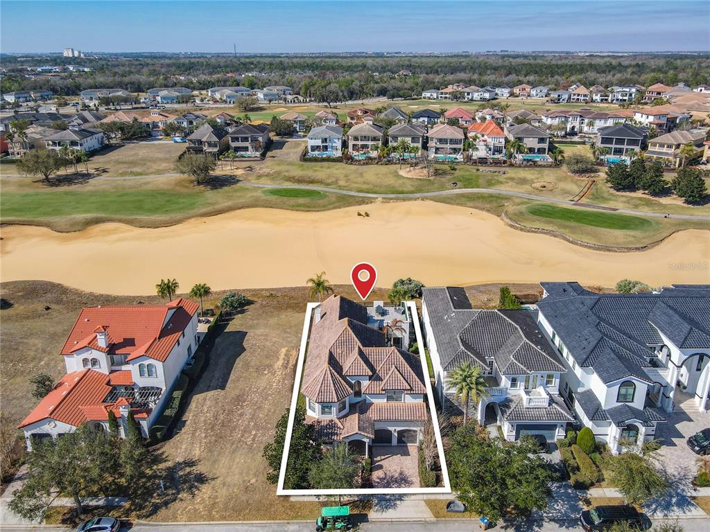 An aerial view shows a two-story house with a tiled roof bordering a golf course — 535 MUIRFIELD LOOP, REUNION, FL
