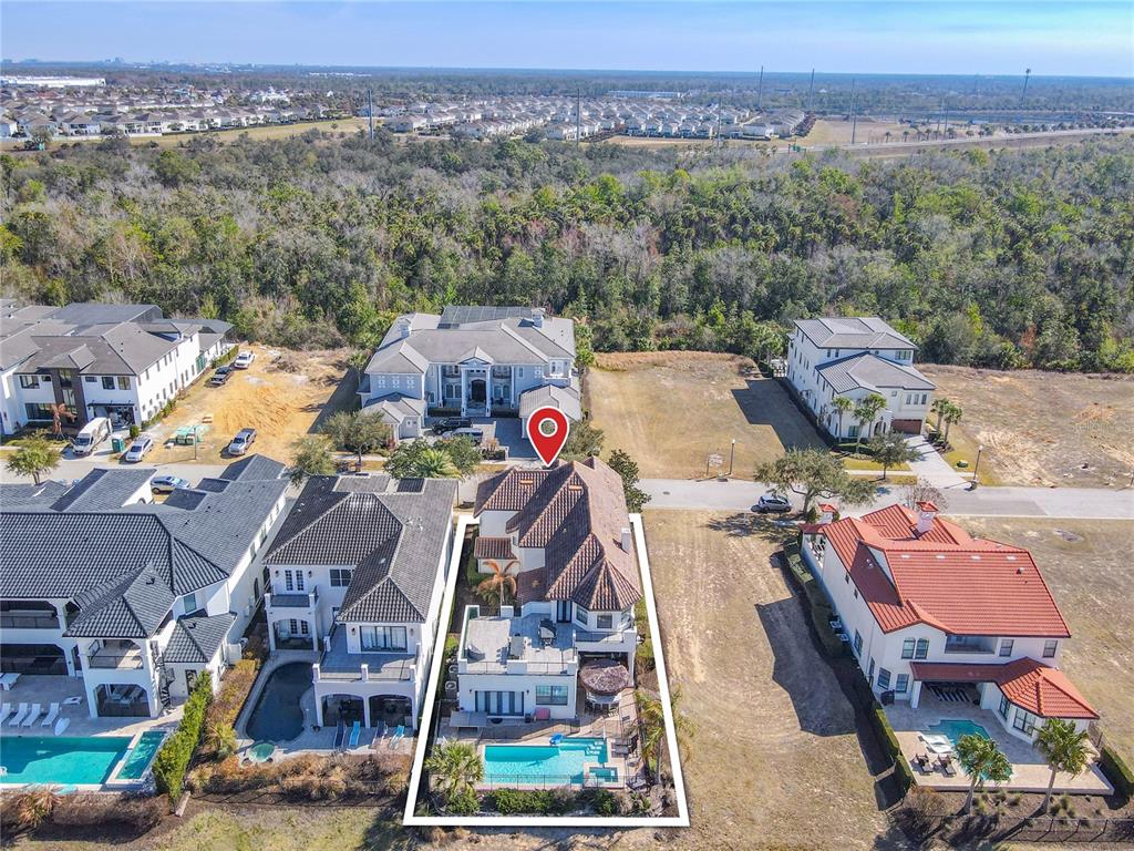 An aerial view shows a two-story house with a swimming pool and a fenced backyard — 535 MUIRFIELD LOOP, REUNION, FL