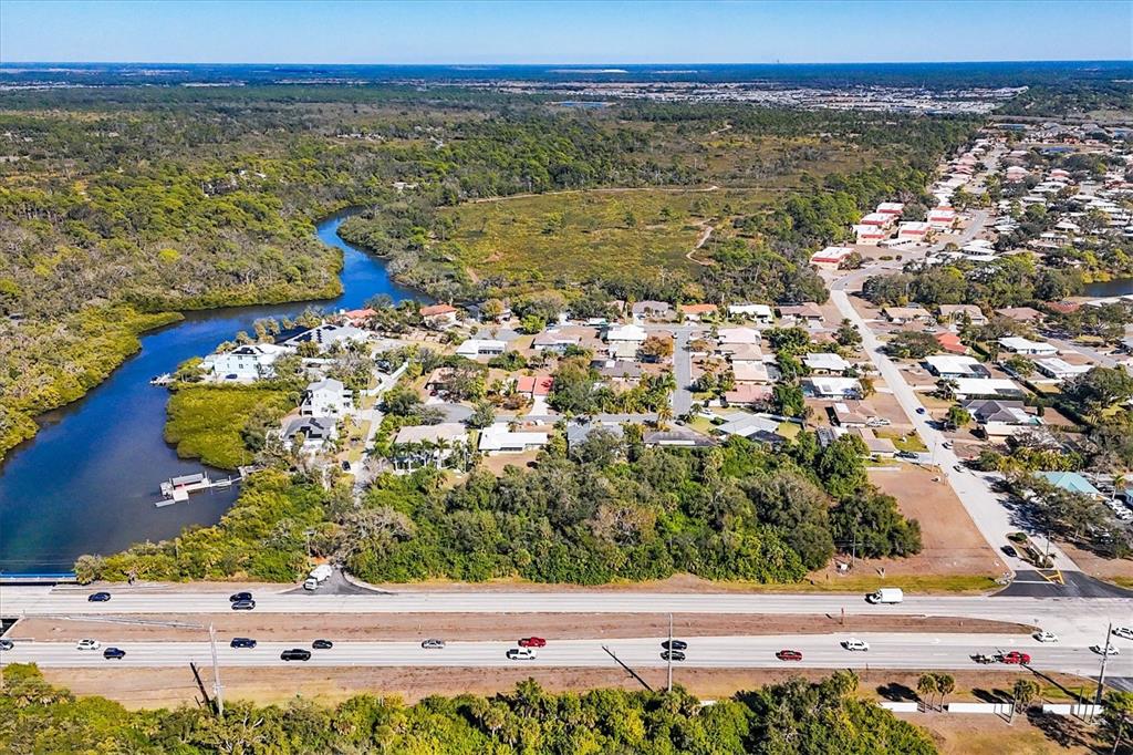 An aerial view shows a residential neighborhood situated along a river near a highway — 2099 S TAMIAMI TRAIL, OSPREY, FL