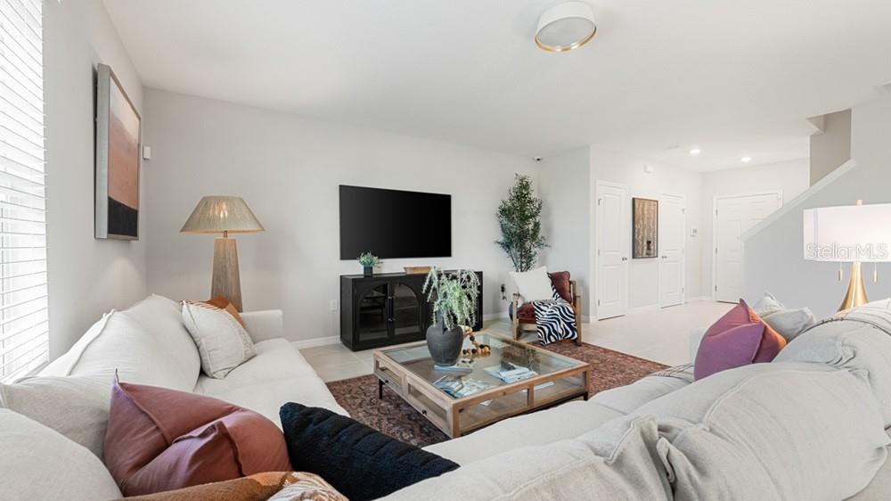 A living room features a white sectional sofa, a glass coffee table, and a television — 13827 SHELLMORE AVENUE, PALMETTO, FL