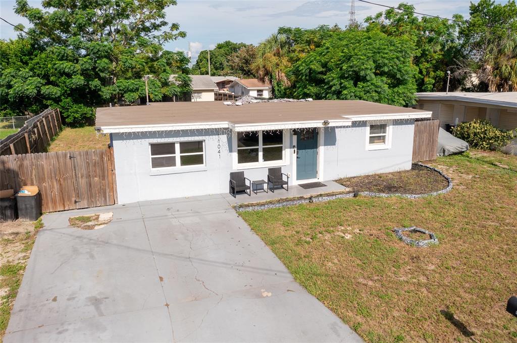 A single-story house with a light blue exterior, a flat roof, and a concrete driveway — 11041 TAFT DRIVE, PORT RICHEY, FL