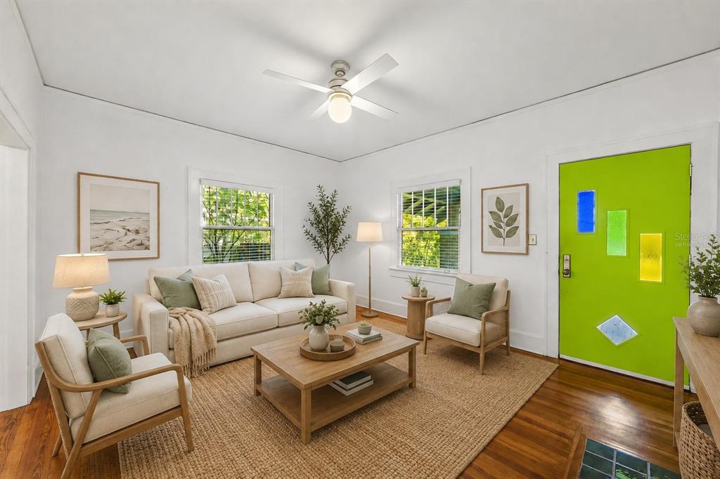 A living room with hardwood floors, a white brick fireplace, and a ceiling fan — 1024 23RD AVENUE N, ST PETERSBURG, FL
