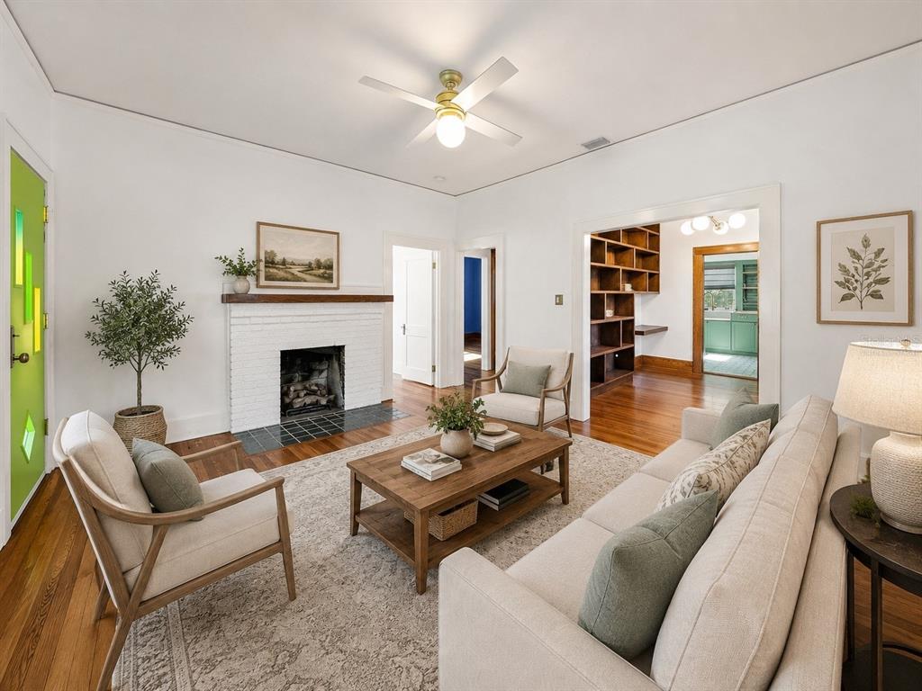 A living room with hardwood floors, a white brick fireplace, and a bright green door — 1024 23RD AVENUE N, ST PETERSBURG, FL