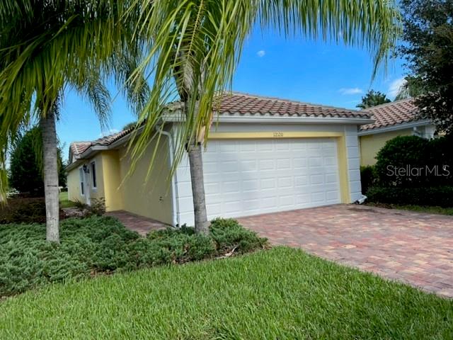 An open garage with a concrete floor, a water heater, and two large trash bins — 12120 TRIPLETAIL LANE, ORLANDO, FL