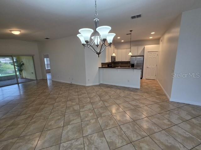 An empty bedroom features beige walls, tan carpet, and a single window with white blinds — 12120 TRIPLETAIL LANE, ORLANDO, FL