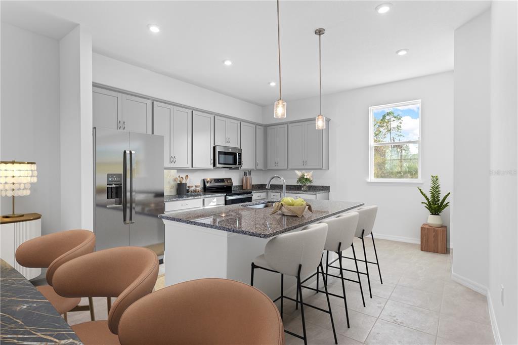 A kitchen features gray cabinets, granite countertops, a central island with bar stools, and appliances — 9612 MONTAGUE STREET, WESTCHASE, FL
