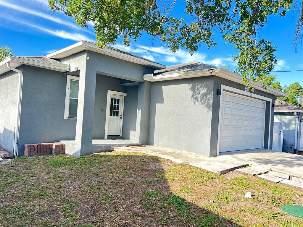 A gray single-story house with a white front door and a one-car garage — 5103 E 18TH AVENUE, TAMPA, FL