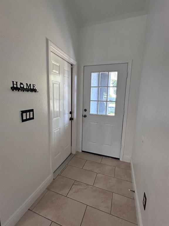 An entryway features white walls, tile flooring, and two white doors — 5103 E 18TH AVENUE, TAMPA, FL