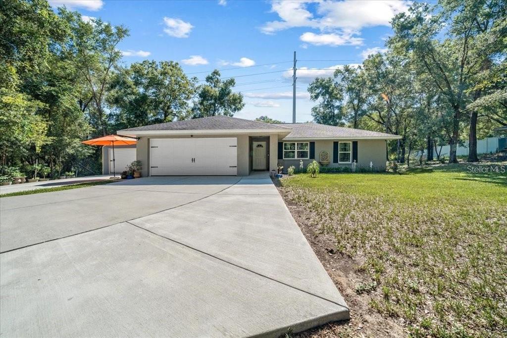 A single-story house with a large concrete driveway, a two-car garage, and a front lawn — 543 N ROOKS AVENUE, INVERNESS, FL