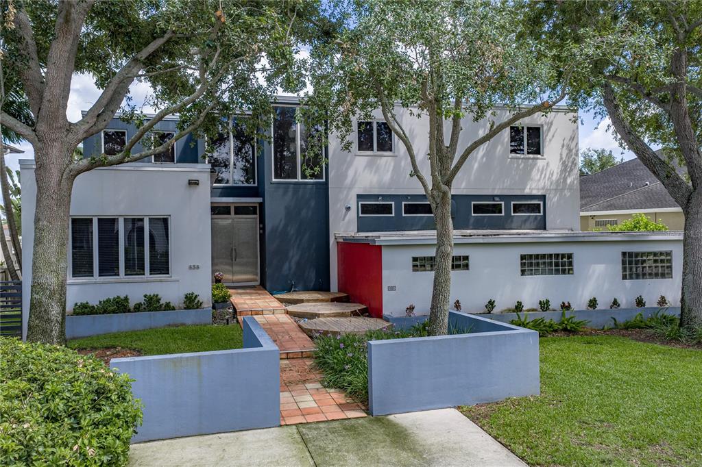 A two-story modern house features a flat roof, glass block windows, and a tiled walkway — 838 MONTEREY BOULEVARD NE, ST PETERSBURG, FL