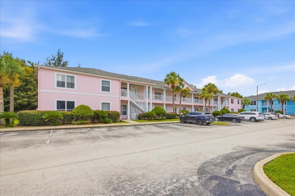 A two-story pink apartment building with an outdoor staircase and a parking lot in front — 3157 SUN LAKE COURT UNIT B, KISSIMMEE, FL