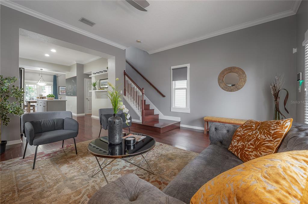 A living room features gray walls, hardwood floors, a staircase, and a patterned area rug — 412 E AMELIA AVENUE, TAMPA, FL