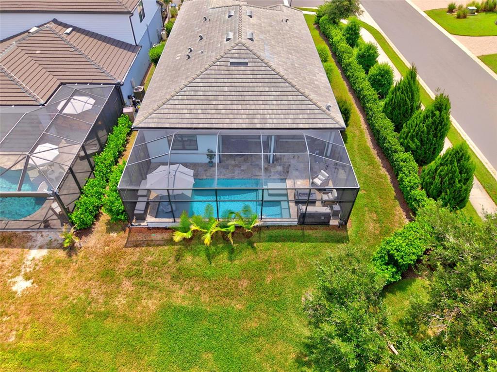 An aerial view of a house with a screened-in pool and patio area — 704 PINTAIL COVE, BRADENTON, FL
