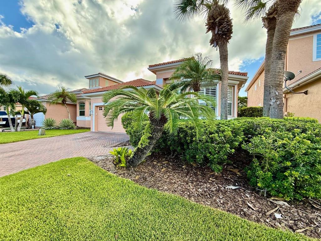 A peach-colored house with a tiled roof, palm trees, and a brick driveway — 1605 SAND KEY ESTATES COURT, CLEARWATER, FL