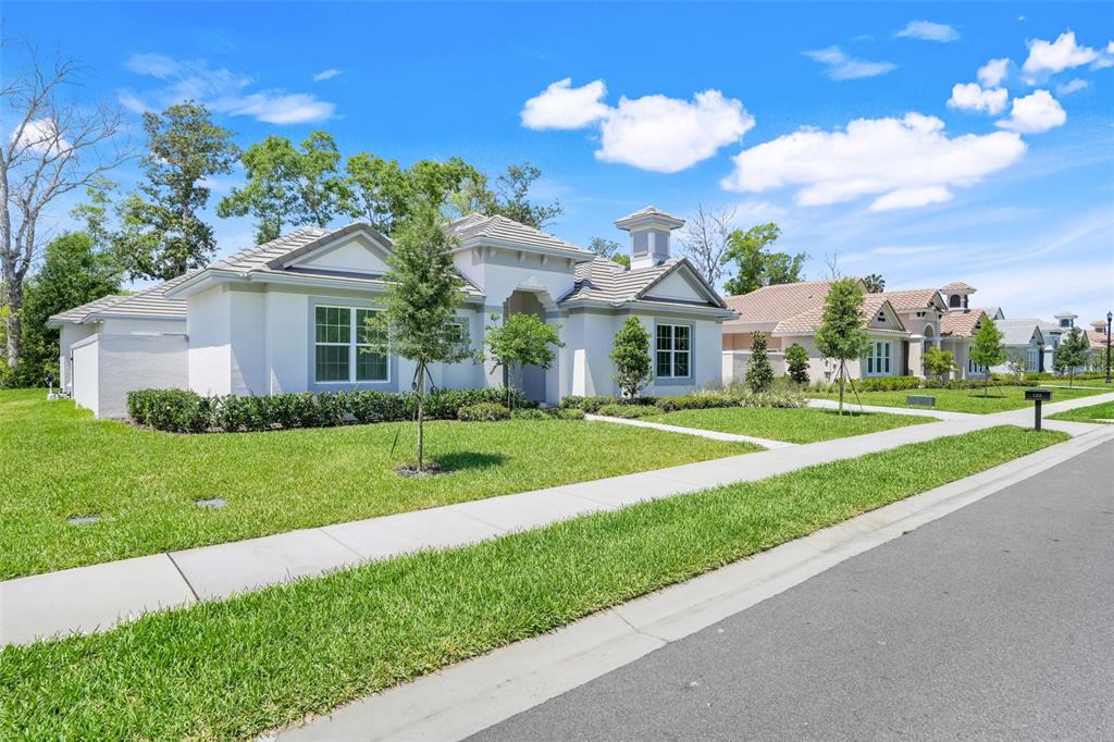 A single-story suburban house with a light-colored stucco exterior and a tiled roof — 132 NEW LEATHERWOOD DRIVE, PALM COAST, FL