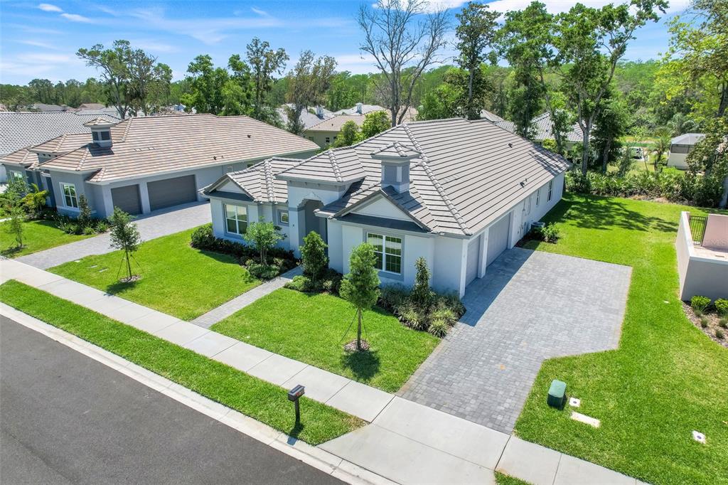 An aerial view shows a single-story house with a tiled roof and a paved driveway — 132 NEW LEATHERWOOD DRIVE, PALM COAST, FL