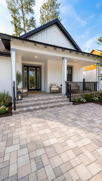 A modern house exterior features a covered porch with stone steps and a paved patio — 5934 SUMMIT VIEW DRIVE, BROOKSVILLE, FL
