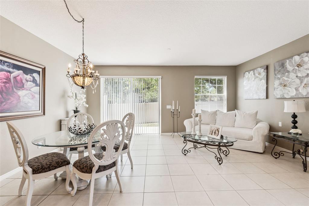 A dining and living area with tile floors, a glass-top table, and a white sofa — 7506 CRANES CREEK COURT UNIT 30, WINTER PARK, FL