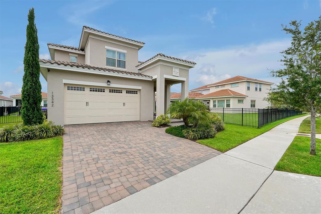 A two-story suburban house with a paved driveway, a two-car garage, and a fenced yard — 13342 BROMBOROUGH DRIVE, ORLANDO, FL