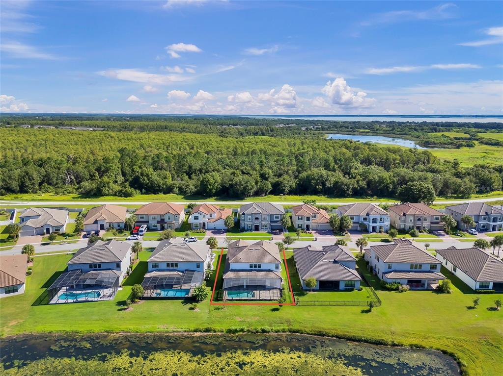 An aerial view of a suburban neighborhood featuring a house with a screened-in pool — 2920 AGOSTINO TERRACE, KISSIMMEE, FL