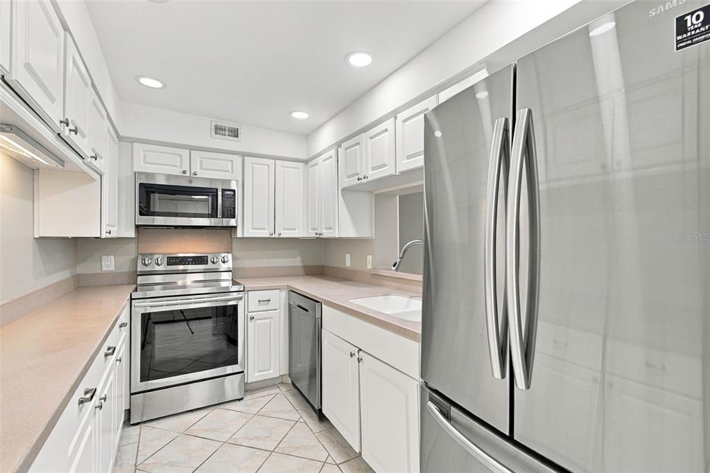 A kitchen with white cabinets, stainless steel appliances, and light-colored countertops — 4141 BAYSHORE BOULEVARD UNIT 1106, TAMPA, FL