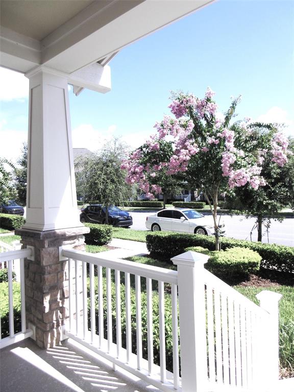 A view from a covered porch looking out toward a street with cars and flowering trees — 2252 CELEBRATION BOULEVARD, CELEBRATION, FL