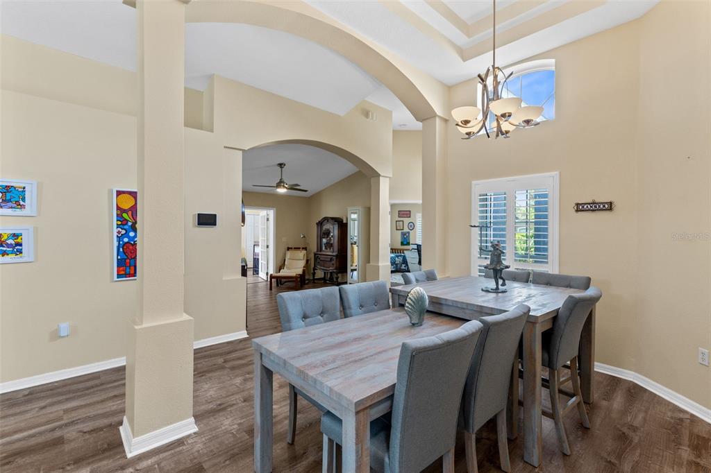 A dining room with a wooden table, gray upholstered chairs, and a chandelier — 216 TAVESTOCK LOOP, WINTER SPRINGS, FL