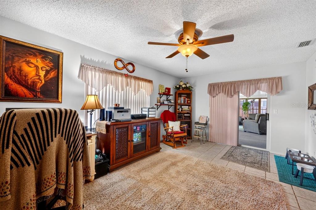 A living room with a ceiling fan, a wooden media console, and a rocking chair — 2956 BRISTOL LANE, SOUTH DAYTONA, FL