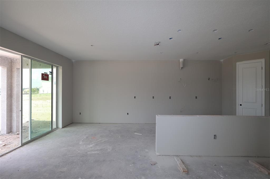 An unfinished kitchen features light gray cabinets, a central island, and tile flooring — 5284 HIGH LINE DRIVE, ST CLOUD, FL