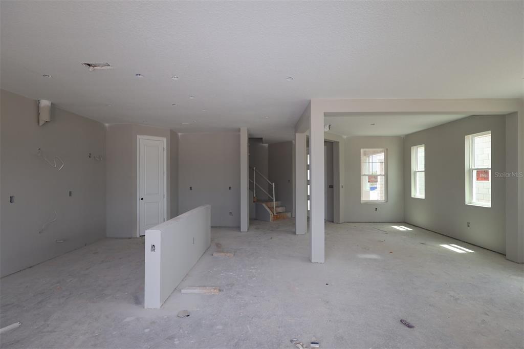 An empty room with light gray walls, white trim, and two windows overlooking houses — 5284 HIGH LINE DRIVE, ST CLOUD, FL