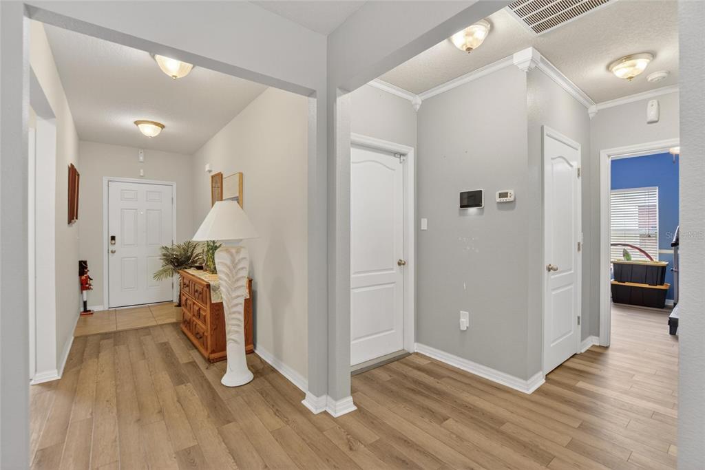 A bright entryway features light wood-look flooring, gray walls, and white interior doors — 255 HAINES BOULEVARD, WINTER HAVEN, FL