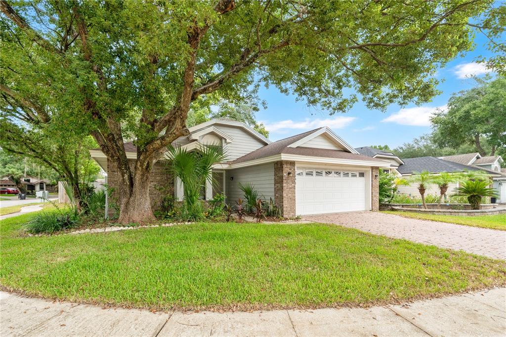 A single-story house with gray siding, a brick facade, and a two-car garage — 2141 WEKIWA OAKS DRIVE, APOPKA, FL