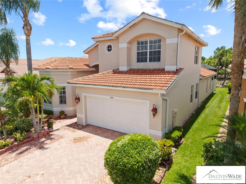 An exterior view of a two-story house with a tiled roof and brick driveway — 5044 SANDY BROOK CIRCLE, WIMAUMA, FL