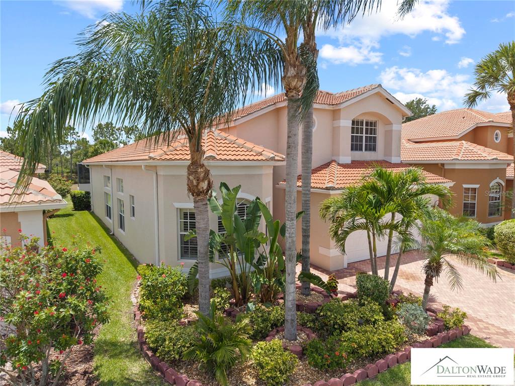 A two-story stucco house with a tile roof and palm trees in the front yard — 5044 SANDY BROOK CIRCLE, WIMAUMA, FL