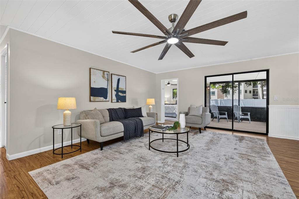 A living room features a white plank ceiling, wood floors, a sofa, and two armchairs — 6170 SUNDOWN DRIVE, ST PETERSBURG, FL