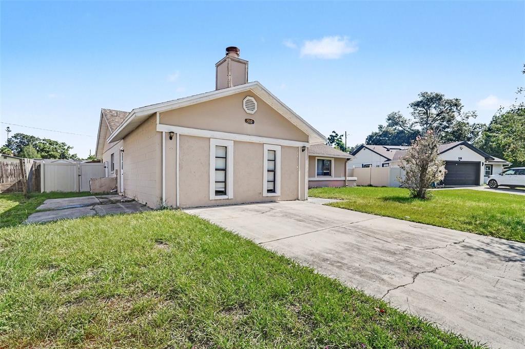 A beige single-story house with a concrete driveway and two vertical windows on the front — 510 WAVECREST DRIVE, ORLANDO, FL