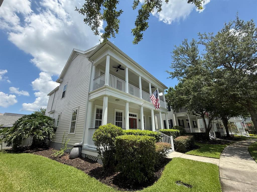 A two-story house with white siding, a double-decker porch, and a front yard — 813 OAK SHADOWS ROAD, CELEBRATION, FL