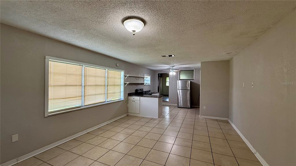 A kitchen features white cabinets, a stainless steel stove, a double sink, and tiled floors — 1310 N COMBEE ROAD UNIT 7, LAKELAND, FL