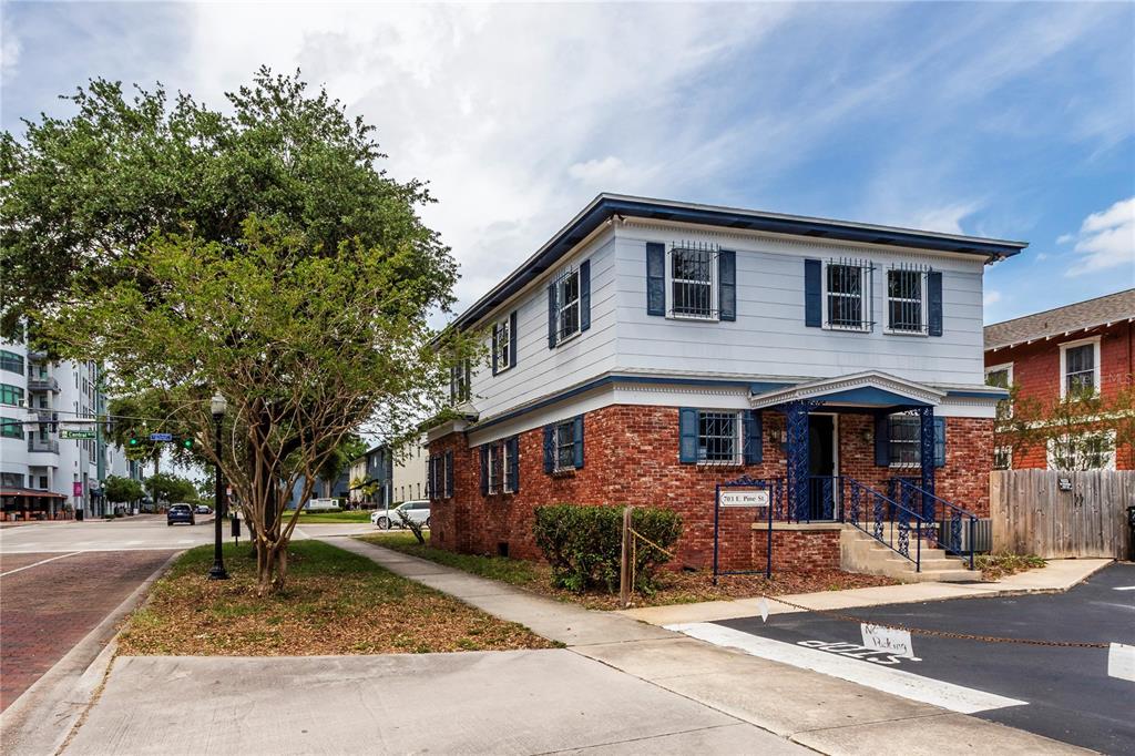 A two-story building with a brick lower level and light-colored siding on the upper floor — 703 E PINE STREET, ORLANDO, FL