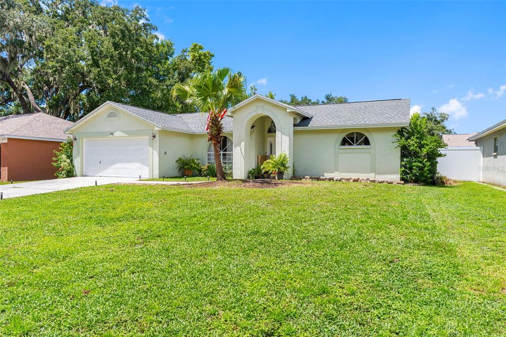 A single-story house with a white garage, arched entryway, and a large front lawn — 1742 STAYSAIL DRIVE, VALRICO, FL