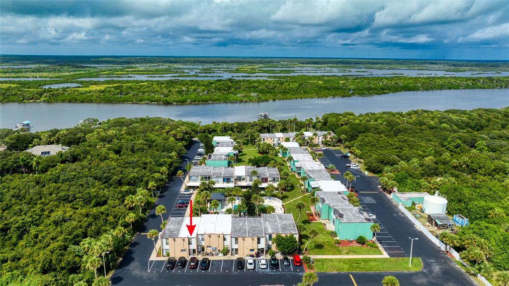 An aerial view shows a multi-unit residential complex with parking lots surrounded by dense vegetation — 5500 OCEAN SHORE BOULEVARD UNIT UT58, ORMOND BEACH, FL