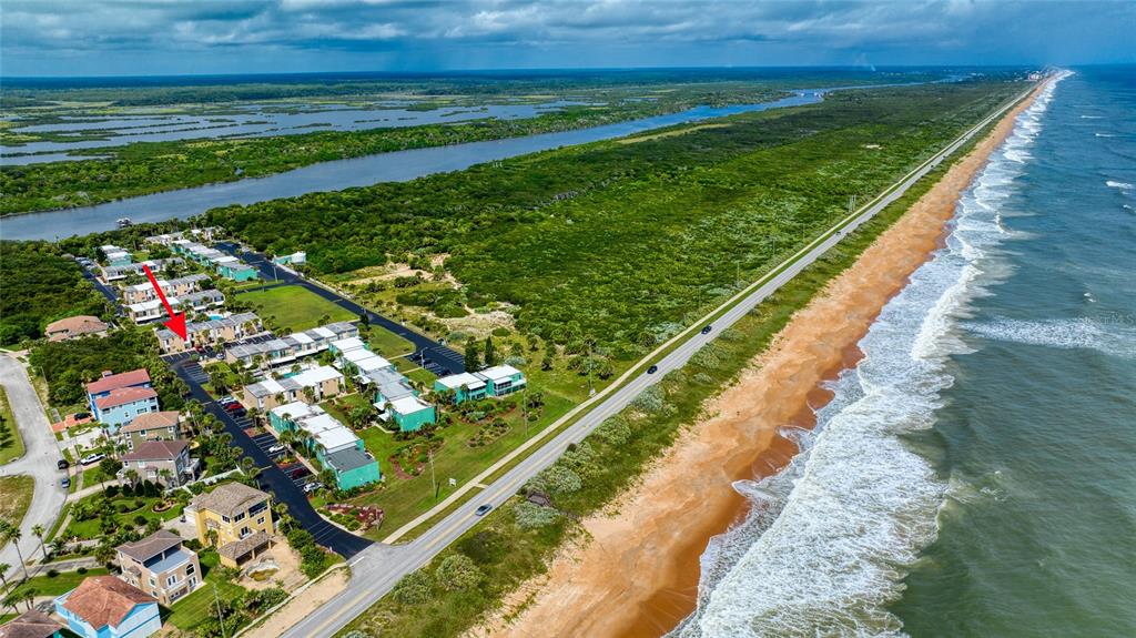 An aerial view shows a coastal residential complex situated between a road and the ocean — 5500 OCEAN SHORE BOULEVARD UNIT UT58, ORMOND BEACH, FL