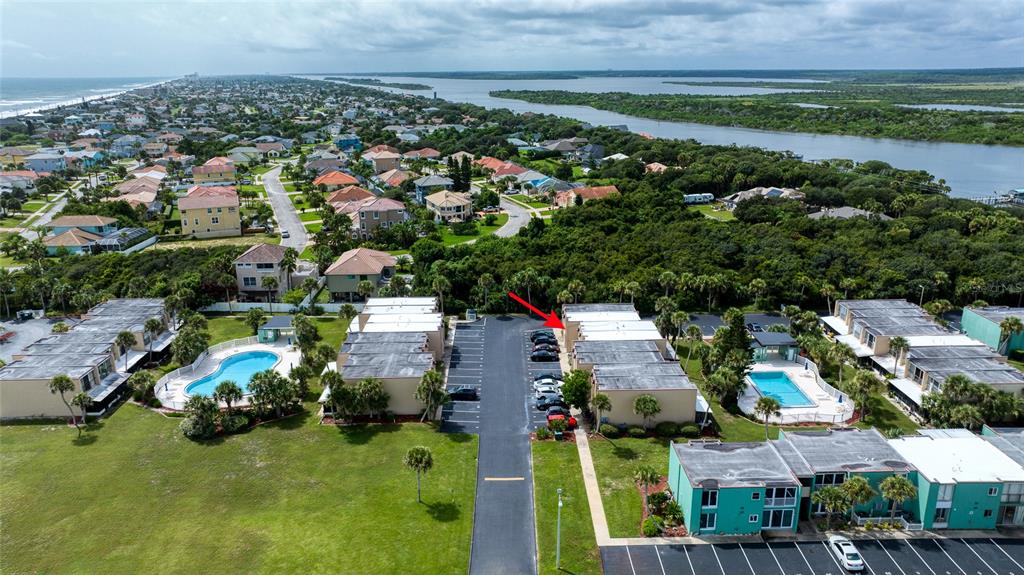 An aerial view shows a residential complex with swimming pools, parking lots, and surrounding vegetation — 5500 OCEAN SHORE BOULEVARD UNIT UT58, ORMOND BEACH, FL