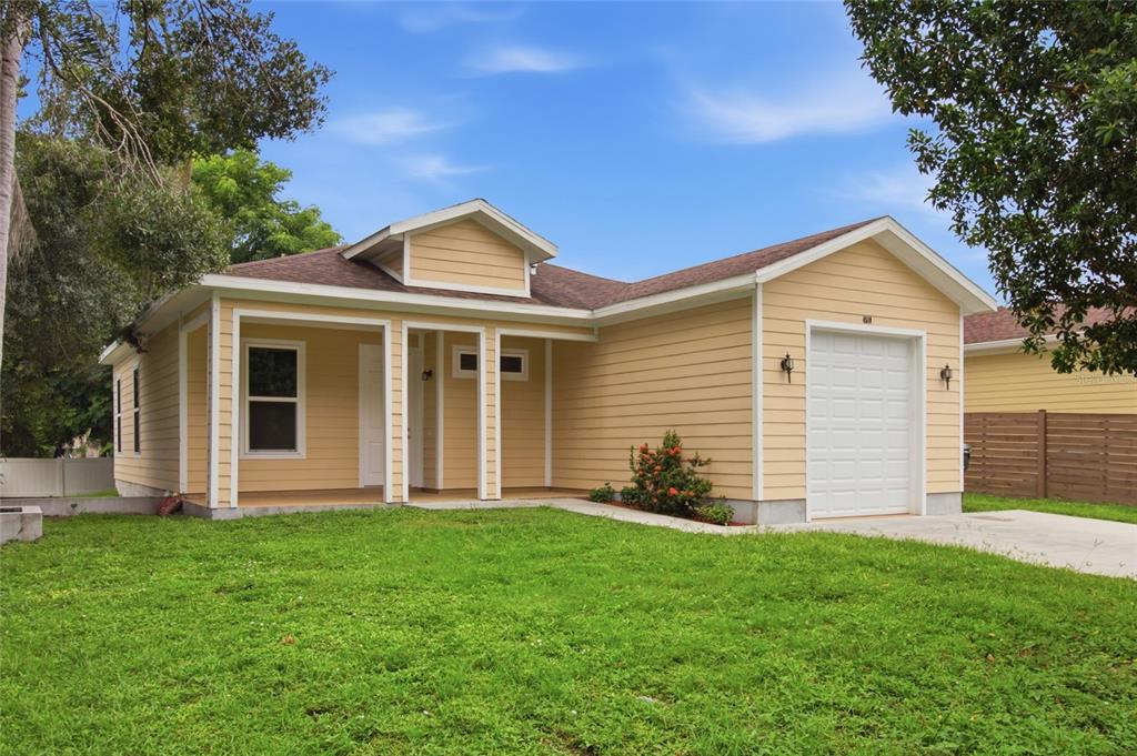 A single-story house with yellow siding, a front porch, and an attached one-car garage — 4510 WILKINSON ROAD, SARASOTA, FL