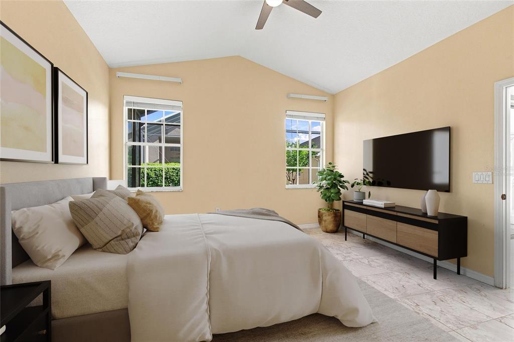This is a digitally staged bedroom featuring a vaulted ceiling, tile flooring, and a wall-mounted television — 140 MOSS LN, DAVENPORT, FL